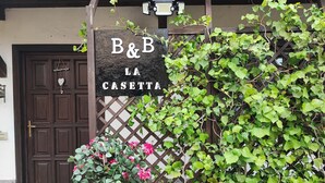 Eine Holztür mit einem Schild darüber, auf dem 'B&B LA CASETTA' steht.