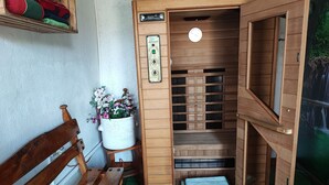 Eine Sauna mit Holzvertäfelung, einer Sitzbank und einem Blumentopf.