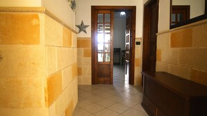 A hallway with a wooden door, a star decoration, and a tiled floor.