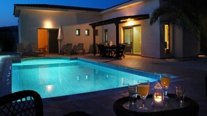 A swimming pool with lounge chairs and a table with drinks, surrounded by a building with doors and windows. - 'The Winning Post' - 3 Bed, 2 Bath, Single Storey Villa with Private Pool in Sea Caves (Peyia)