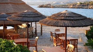 A beachside restaurant with thatched umbrellas and wooden tables. - 'The Winning Post' - 3 Bed, 2 Bath, Single Storey Villa with Private Pool in Sea Caves (Peyia)