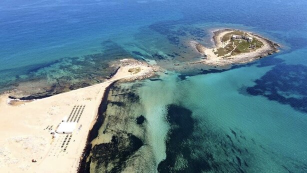 An aerial view of a coastal area with a sandy beach, a small island with structures, and clear blue waters. - Villa Fascinosa with sea / island currents view (portopalo di capo passero)