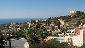 Un quartier résidentiel situé sur la côte, avec des maisons, une piscine et une vue sur la mer.