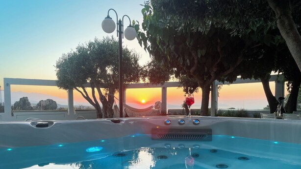 A hot tub with a sunset view, surrounded by trees and a hammock. - Unique Sea View,Sunset with Privacy! Bedrooms with ensuite bathroom,Jacuzzi,GYM (Rethymno)