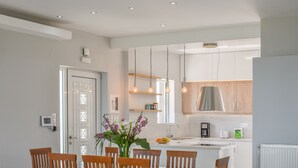 A modern kitchen with white cabinets, a stainless steel range hood, and pendant lighting. - Unique Sea View,Sunset with Privacy! Bedrooms with ensuite bathroom,Jacuzzi,GYM (Rethymno)