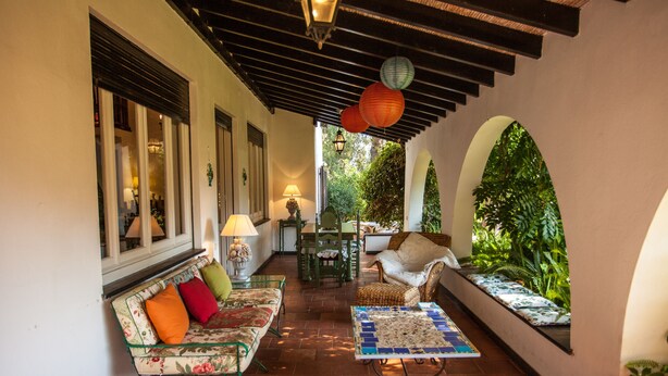 Un espace extérieur aménagé, abrité et doté d’un canapé, de chaises et d’une table.