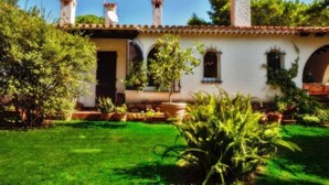 Il s’agit d’un bâtiment traditionnel, doté d’un toit en tuiles, de fenêtres en arc de cercle et d’un jardin bien entretenu, où l’on trouve diverses plantes et une pelouse.