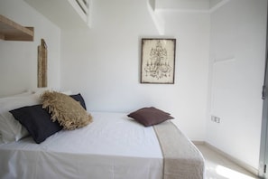 A bedroom with a bed, pillows, a wall-mounted artwork, and a door. - Echoes of inspiration & calmness! `Urban  Blue` (Rethymno)