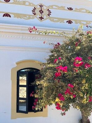 A building with a white facade, a decorative floral pattern, and a window with a black frame. - Stunningly Restored Farmhouse With Private Pool, Panoramic Views & Large Garden (Barranco De Sao Miguel, Azinheiro)