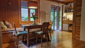Un comedor de madera con una mesa, sillas y un florero.