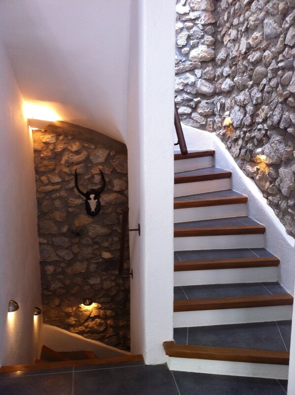 Eine Treppe mit Holzboden und einer Steinwand.