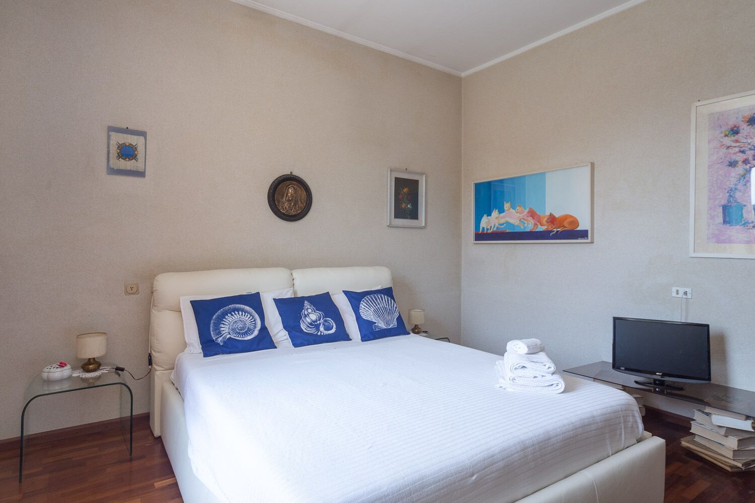 Ett hotellrum med en säng, en tv och ett skrivbord.
