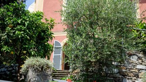 A building with a stone wall and red flowers in front.
