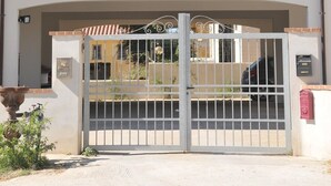 Ein zweistöckiges Gebäude mit einem zentralen Eingang, Balkonen in jeder Etage und einem verschlossenen Zugangsbereich.