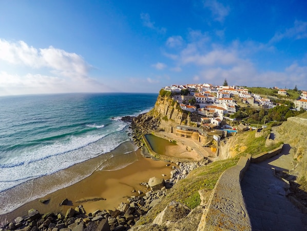 A coastal town with buildings on a cliff overlooking the sea.