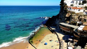 A coastal hotel with a beach, ocean view, and cliffside architecture. - Azenhas Rustic Beach House (Lisboa)