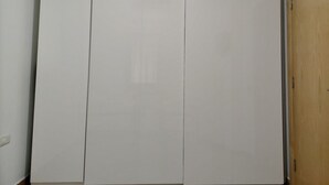 Un armario cerrado con un interruptor de luz y una puerta de madera a la derecha.