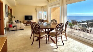 A spacious living area with a dining table, chairs, a sofa, and a TV. - Villa with spectacular sea views and private pool in Begur (Begur)