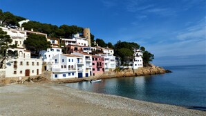A coastal village with colorful buildings, a beach, and a boat on the water. - Villa with spectacular sea views and private pool in Begur (Begur)