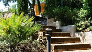 A set of stone steps leading up to a building, surrounded by greenery and a lamp post. - Villa with spectacular sea views and private pool in Begur (Begur)