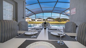 Comedor con una mesa para cuatro, vista a la piscina y un cartel que indica 'No Diving'.