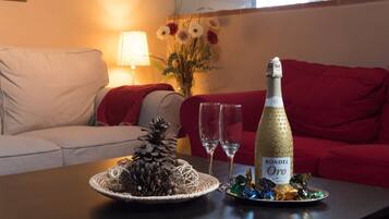 A table with a bottle of RONDEL Oro, two glasses, and a decorative pine cone centerpiece.