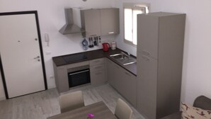 A compact kitchen with a built-in oven, a sink, and a window above the countertop. - ROSA DEI VENTI - SAN PIETRO A MARE (San Pietro a Mare)