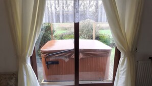 Una stanza con un'ampia finestra, una panca di legno e un termosifone.