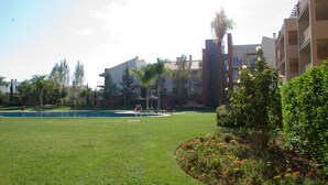 A courtyard with a swimming pool, surrounded by greenery and buildings. - NEWLY REFRUB LUX 2 bed Apart (Sleeps 4) FREE Wi-Fi  Close to Marina Beach & Golf (Vilamoura)