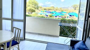 Ein Balkon mit Blick auf einen Poolbereich, einem Tisch und einem Stuhl.