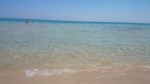 A beach with clear shallow water and a sandy shore. - Trullo in the woods, a few steps from a hiking and cycling trail (Cisternino)