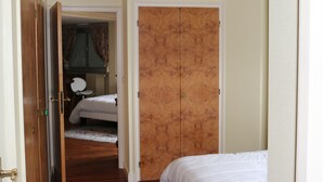 A bedroom with a wooden wardrobe, a bed, and a chair.