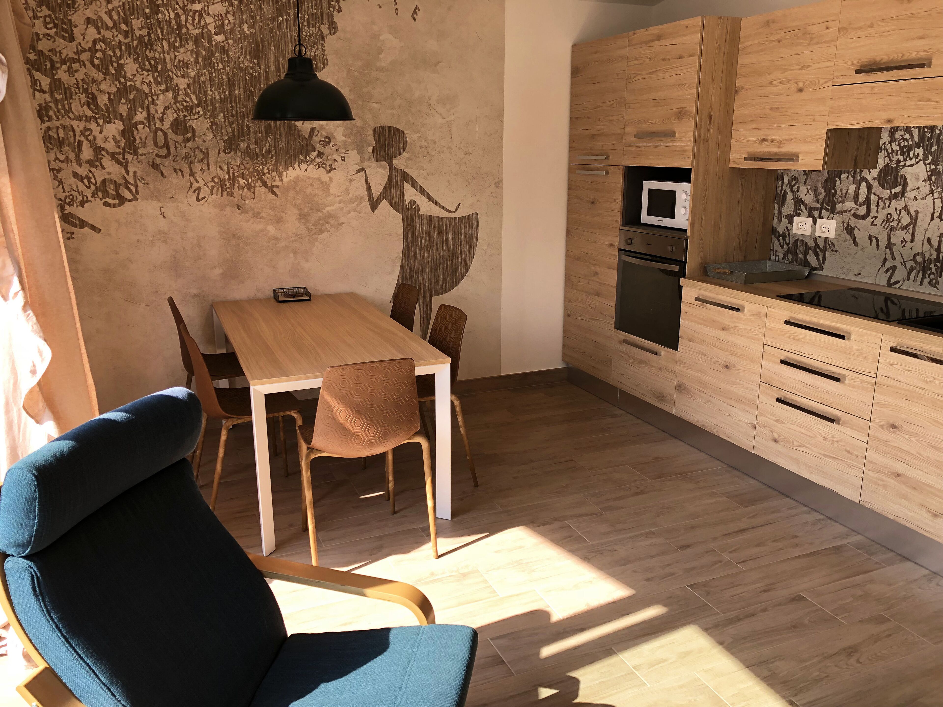A modern kitchen with wooden cabinets, a built-in microwave, and an oven.