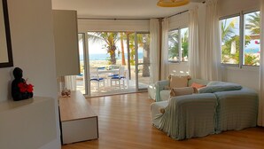 Une pièce avec un canapé, une table et une vue sur la plage.