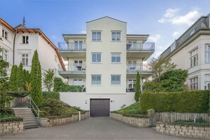 A multi-story residential building with a central entrance, balconies, and surrounding greenery. - Cozy vacation apartment in Ahlbeck with sea view and balcony on Usedom (Ahlbeck)