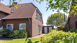 Ein Haus aus Backstein mit Ziegeldach, einem kleinen Fenster und einer Tür.