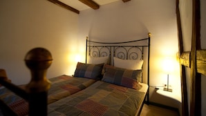 Ein Schlafzimmer mit einem Bett, zwei Nachttischlampen und Holzbalken an der Decke.