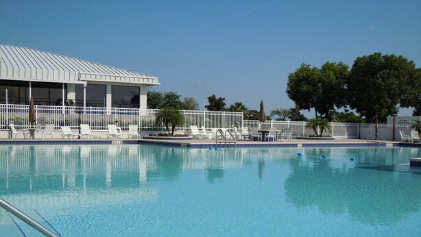 A swimming pool with lounge chairs and a covered area. -  Condo/apt. near Disney, Universal, 3 pools, WIFI,free Parking !  (Florida)