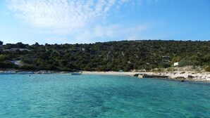 A coastal area with clear turquoise water, a sandy beach, and a hillside with buildings. - Holiday Home in Vinišće with Seaview, Balcony, Air condition, WIFI (3484-1) (Vinišce)
