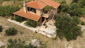 A two-story house with a tiled roof, a balcony, and a stone patio. - Holiday Home in Vinišće with Seaview, Balcony, Air condition, WIFI (3484-1) (Vinišce)