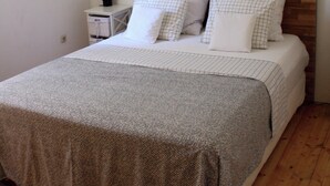 A bedroom with a wooden headboard, a white bedspread, and a hanging mosquito net. - Villa / finca with beautiful terrace & large garden, 5 minutes to the beach, Dalmatia (Ždrelac)