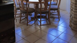A dining area with a stone arch, wooden chairs, a table, and large windows with shutters. - Villa / finca with beautiful terrace & large garden, 5 minutes to the beach, Dalmatia (Ždrelac)