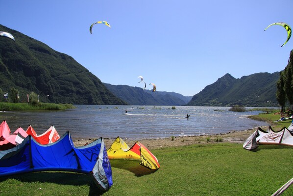A lakeside view with tents and kites.