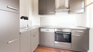 Una cucina moderna con elettrodomestici in acciaio inossidabile, pensili grigi e forno integrato.