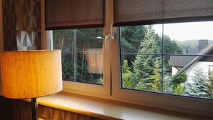 Una ventana con vista a un bosque y una casa.