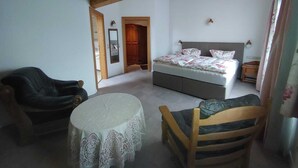 A bedroom with a bed, a chair, a table, and a wardrobe. - Luxury Vacation Apartment (160 sqm) near Neuschwanstein (Schwangau)