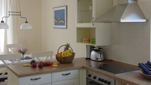 A kitchen with a stove, toaster, and a fruit basket on the counter. - Exclusive Friesenhaus * * * * * with sea views, sauna, wireless, disabled (Husum/Schobüll)