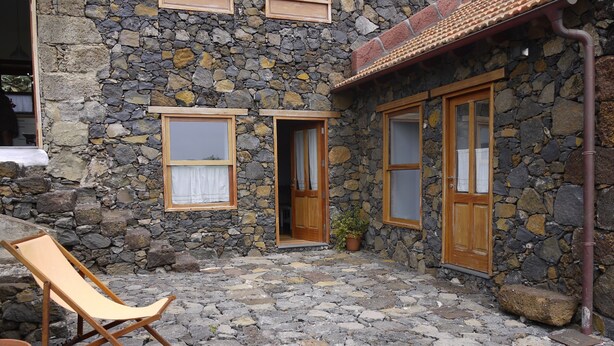 A stone building with a courtyard, two wooden doors, and two windows with curtains. - Newly restored in 2012, rural environment, fully connected, very well connected (Isora)
