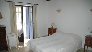 A bedroom with a large bed, a wooden nightstand, a dresser, and a window with curtains. - House redone in VICO- WIFI- 15mns Beaches of SAGONE (Vico)