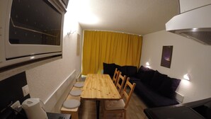 A compact kitchen with a dining table, chairs, a sofa, and a stove. - Arc 1800 - Studio with balcony overlooking Montblanc, at the foot of the slopes for 5 people. (Bourg-Saint-Maurice)